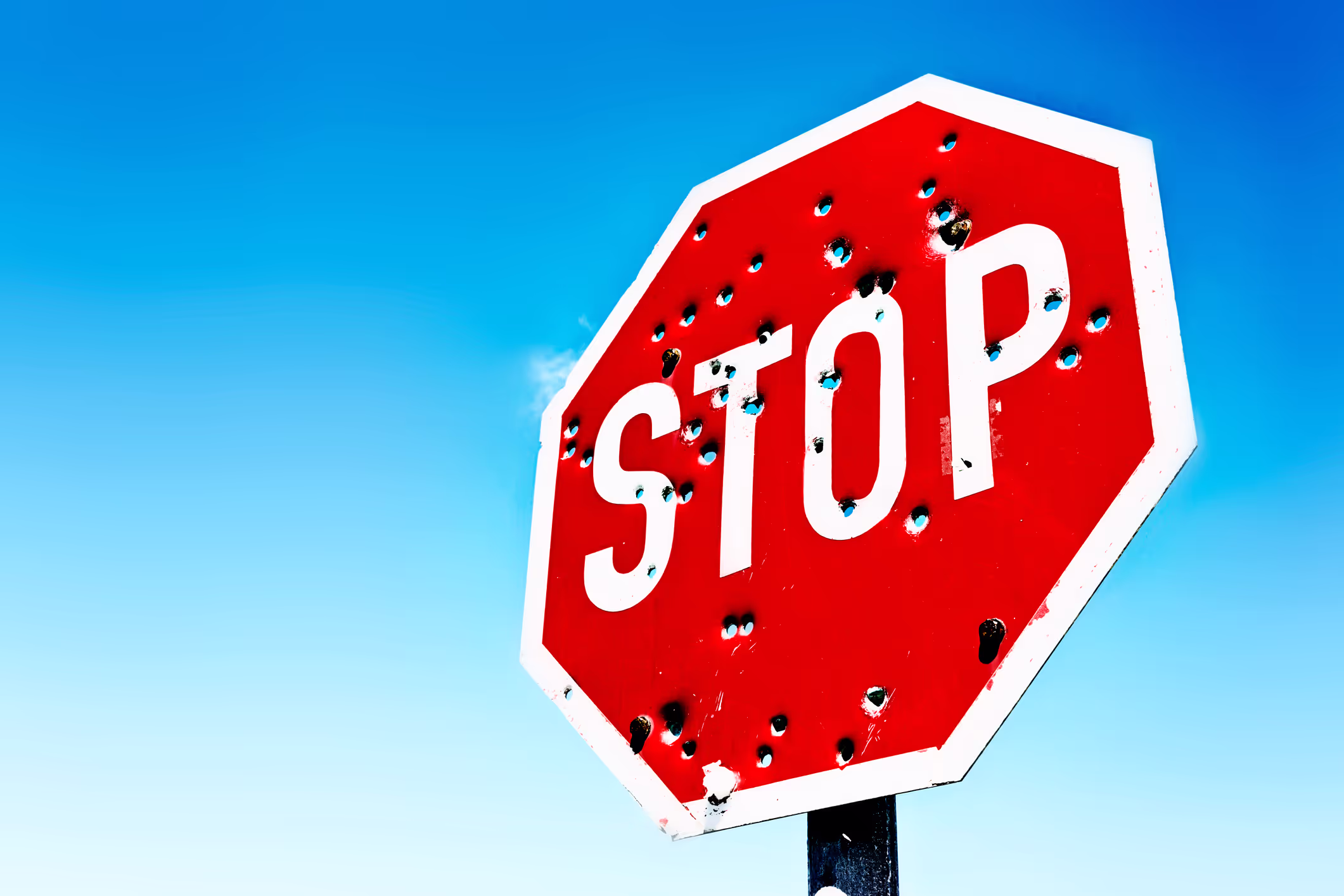 Stop sign image with bullet holes in it